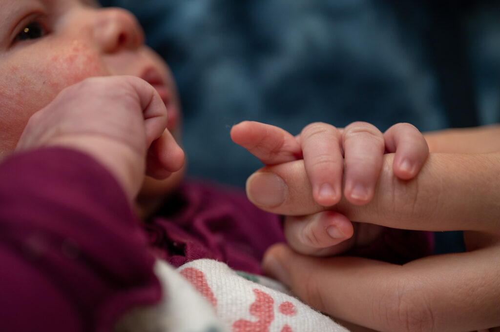 Baby holding mother's finger