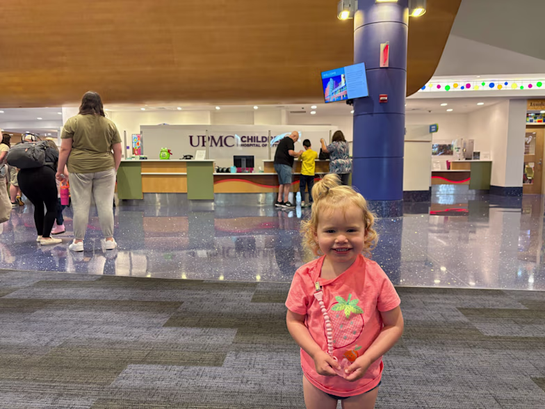 a little girl smiling in the lobby of UPMC Children's Hospital