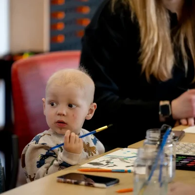 a patient at UPMC Children's holds a paintbrush in an art therapy session